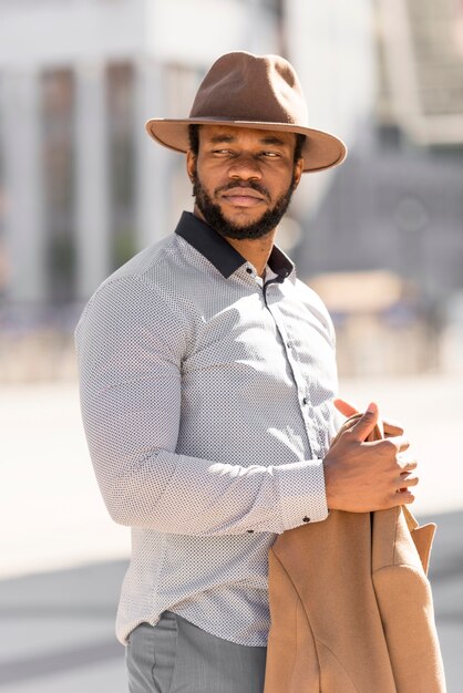 Hombre afroamericano con estilo posando mientras mira lejos