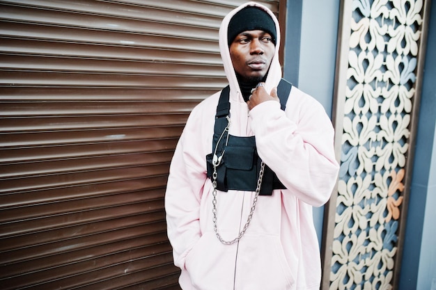 Foto gratuita hombre afroamericano de estilo urbano con estilo en sudadera con capucha rosa posó chico rapero afro