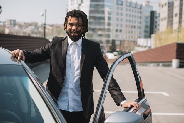 Hombre afroamericano feliz saliendo del coche