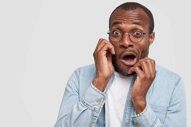 Hombre afroamericano con gafas redondas y camisa vaquera