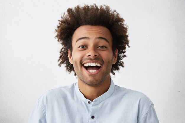 Hombre afroamericano guapo alegre despreocupado con peinado tupido