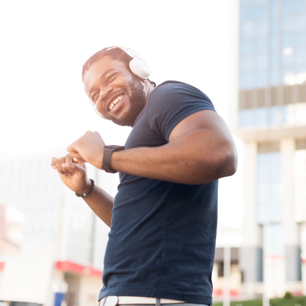 Hombre afroamericano moderno escuchando música a través de auriculares