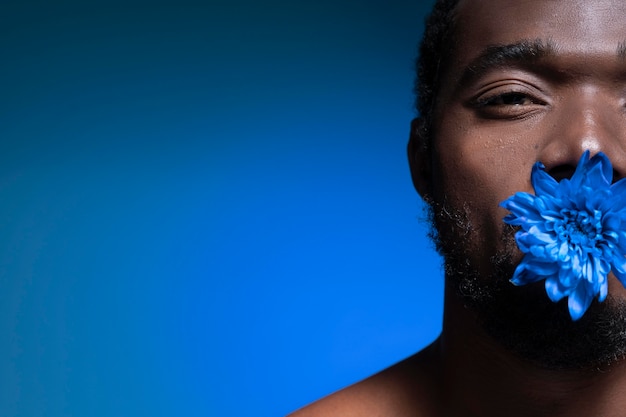 Hombre afroamericano sosteniendo una flor azul
