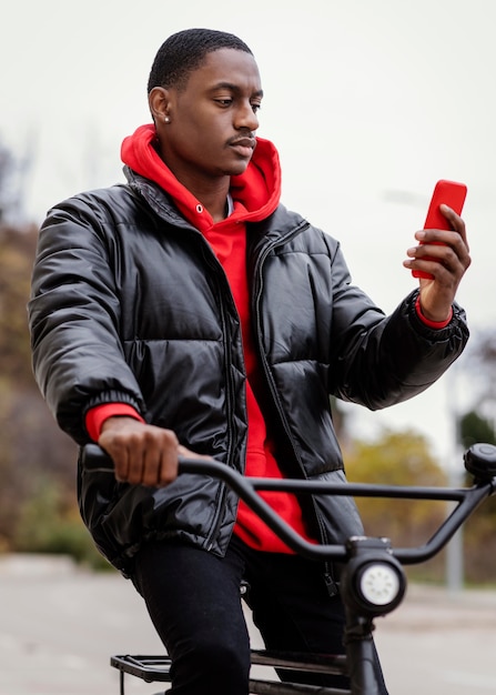 Hombre afroamericano de tiro medio y su bicicleta