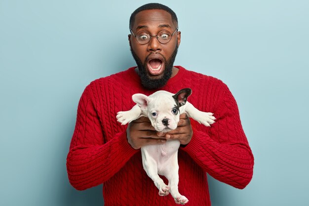 Hombre afroamericano vestido con suéter rojo con perro