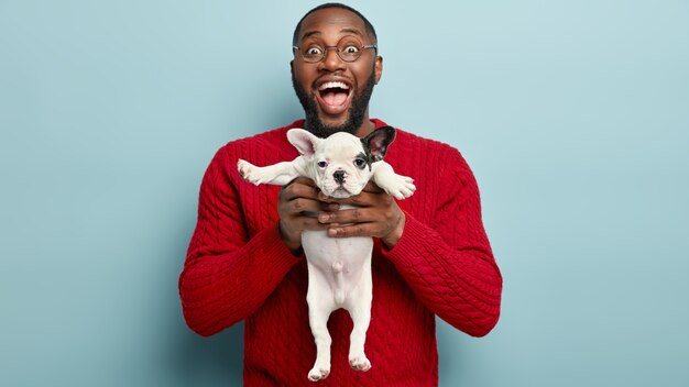 Hombre afroamericano vestido con suéter rojo con perro