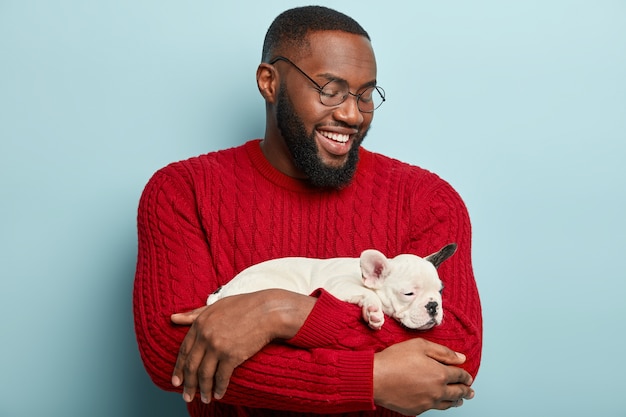 Hombre afroamericano vestido con suéter rojo con perro