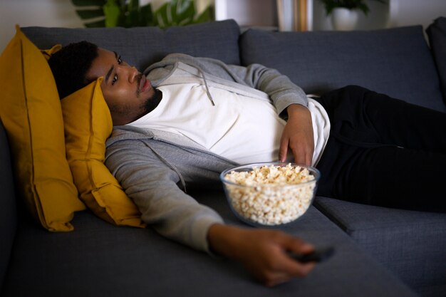 Hombre afroamericano viendo servicio de streaming en casa