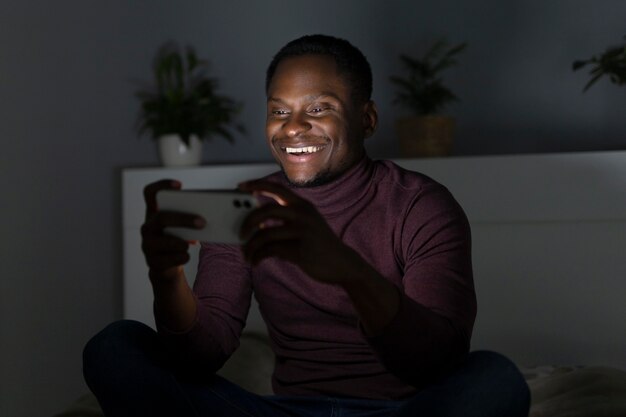 Hombre afroamericano viendo servicio de streaming en interiores