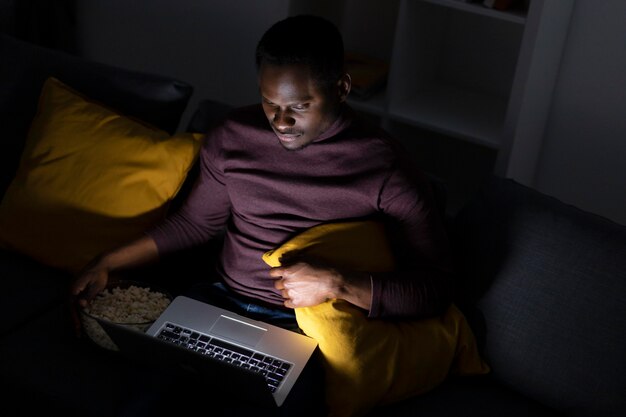 Hombre afroamericano viendo servicio de streaming solo en casa