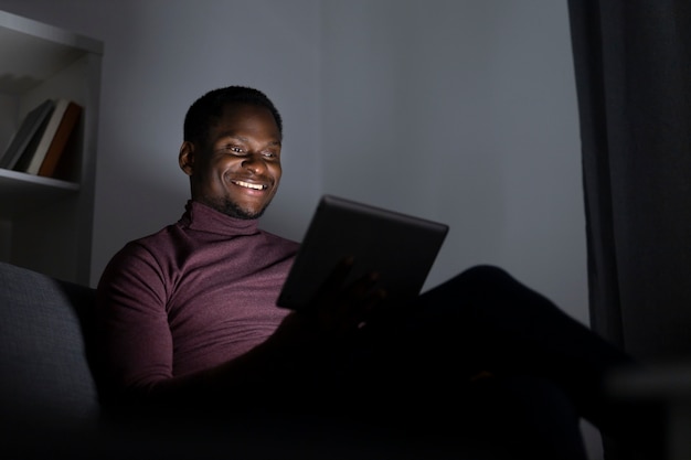 Hombre afroamericano viendo servicio de streaming solo en casa