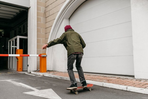 Hombre afuera con patineta en la ciudad.