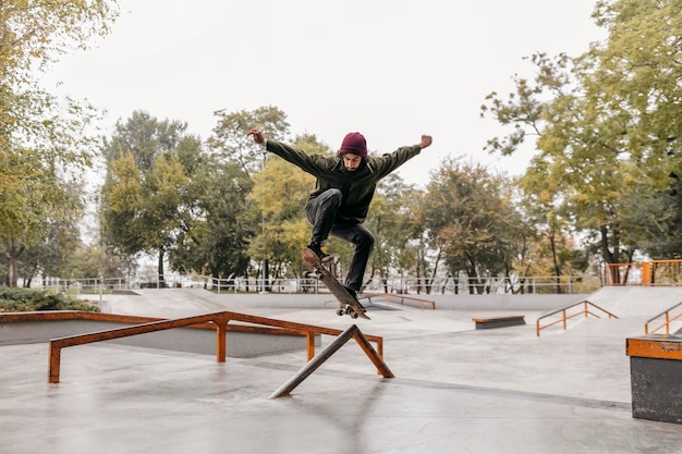 Foto gratuita hombre afuera con patineta en el parque