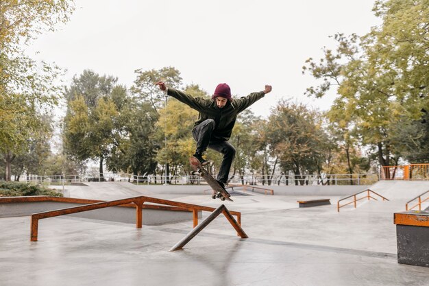 Hombre afuera con patineta en el parque