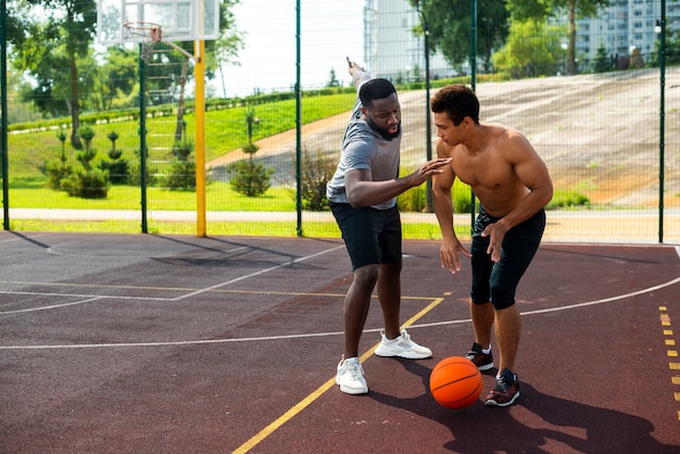 Foto gratuita hombre agresivo jugando baloncesto tiro largo