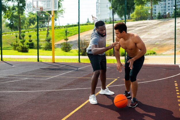 Hombre agresivo jugando baloncesto tiro largo