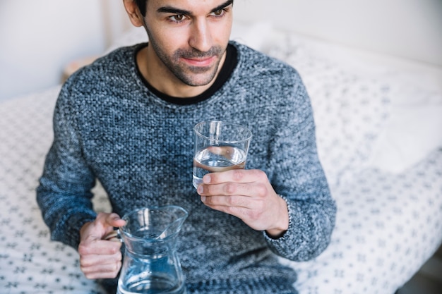 Foto gratuita hombre con agua en la cama