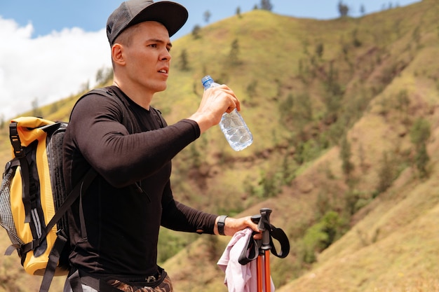 Hombre agua potable trekking en las montañas. bali