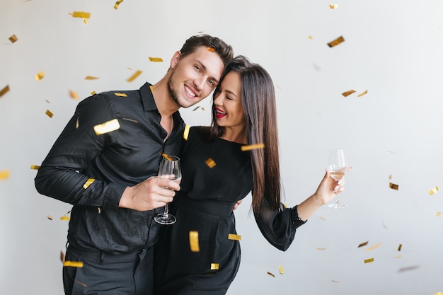 Foto gratuita hombre alegre abrazando a su esposa en la fiesta de cumpleaños de un amigo