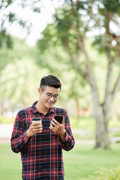 Hombre alegre con café y teléfono