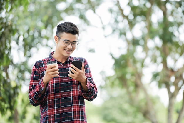 Foto gratuita hombre alegre con café y teléfono.