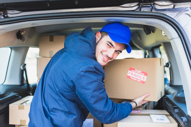 Hombre alegre con cajas para la entrega