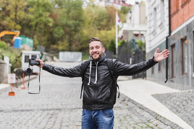 Foto gratuita hombre alegre con cámara en la calle