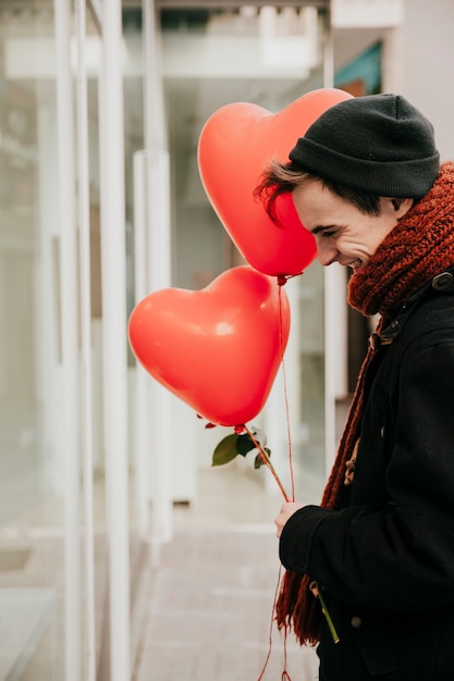 Foto gratuita hombre alegre con globos y rosas