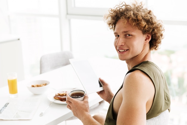 Hombre alegre guapo con tablet PC