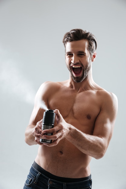 Hombre alegre jugando con desodorante