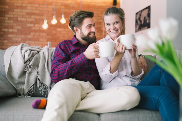 Hombre alegre y mujer con tazas