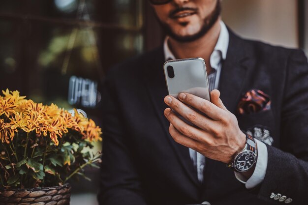 Un hombre alegre y ocupado acaba de recibir un mensaje muy bueno de su teléfono inteligente.