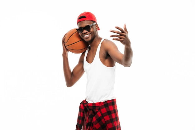 Hombre alegre con pelota de baloncesto e invitando a jugar