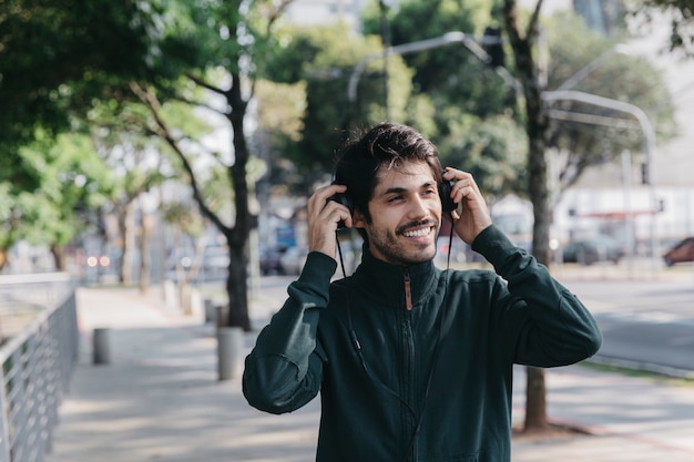 Hombre alegre ponerse auriculares