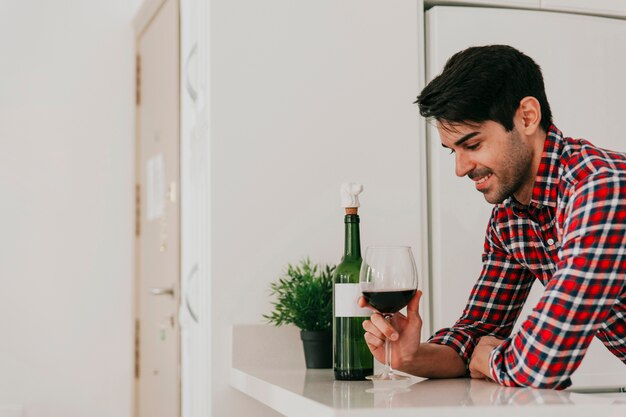 Hombre alegre que tiene vino en casa