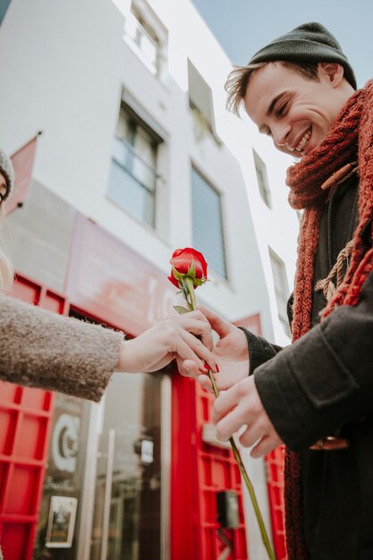 Hombre alegre que toma el regalo color de rosa