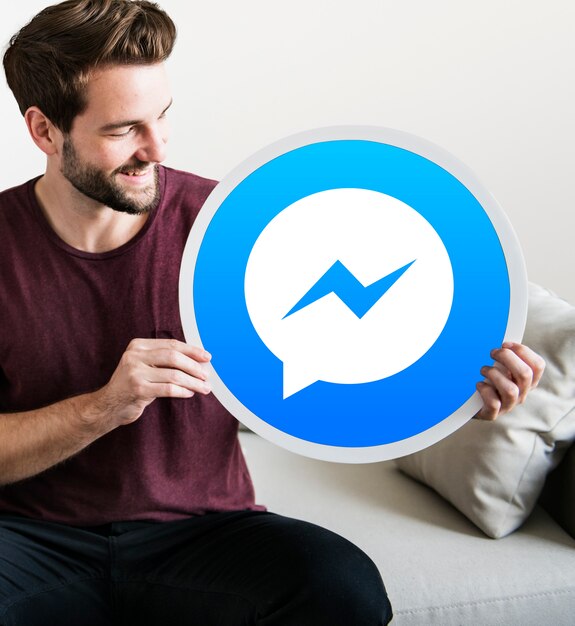 Hombre alegre sosteniendo un ícono de Facebook Messenger