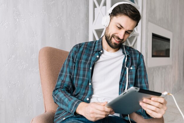 Hombre alegre con tableta escuchando música