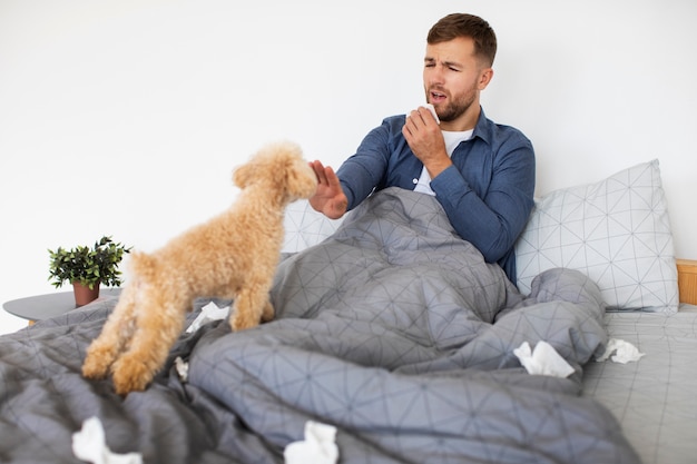 Foto gratuita hombre con alergia a los perros tiro completo