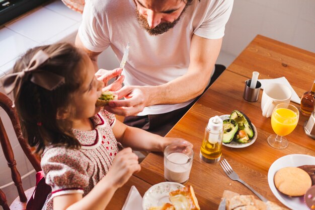 Hombre alimentación chica en el desayuno