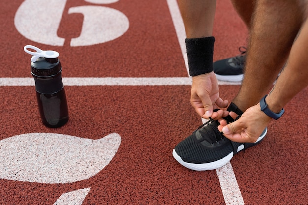 Hombre de alto ángulo atándose los cordones de los zapatos