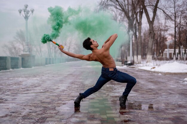 Hombre de alto ángulo bailando ballet con polvo de color