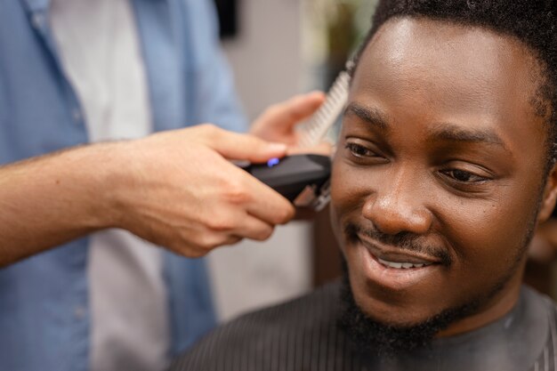 Foto gratuita hombre de alto ángulo cortándose el pelo