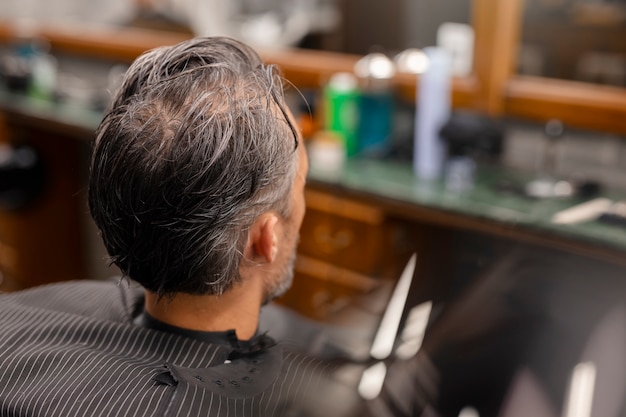 Hombre de alto ángulo cortándose el pelo