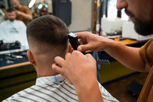 Hombre de alto ángulo cortándose el pelo