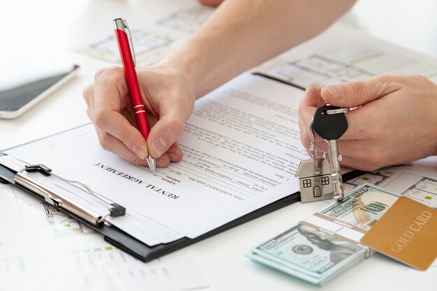 Hombre de alto ángulo firmando un contrato para un nuevo hogar