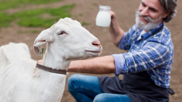 Hombre de alto ángulo con leche de cabra