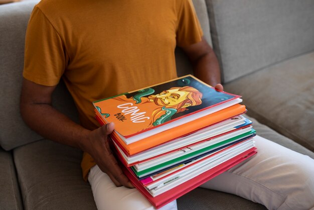 Hombre de alto ángulo leyendo cómics en casa