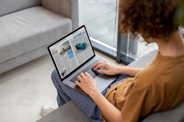 Hombre de alto ángulo leyendo revista digital