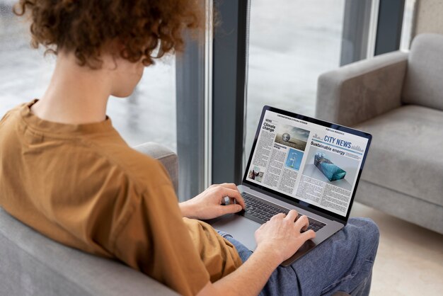 Hombre de alto ángulo leyendo revista digital